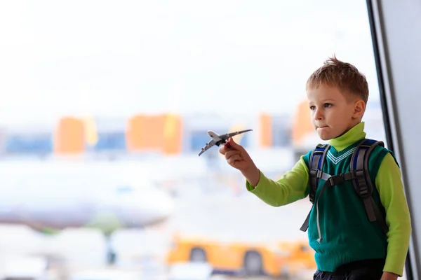 Niño jugando con avión de juguete en el aeropuerto — Foto de Stock