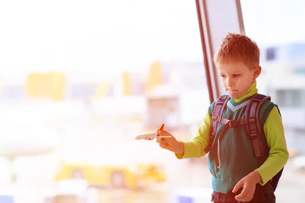 Маленький мальчик играет с игрушечным самолетом в аэропорту — стоковое фото