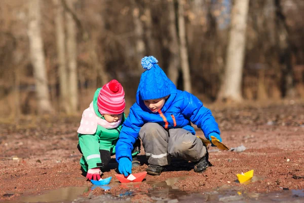 Menino e menina brincando com a água na primavera — Fotografia de Stock