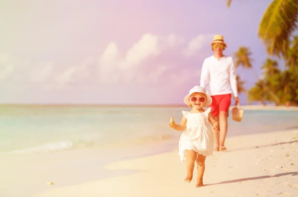 Schattig klein meisje lopen op strand met vader — Stockfoto