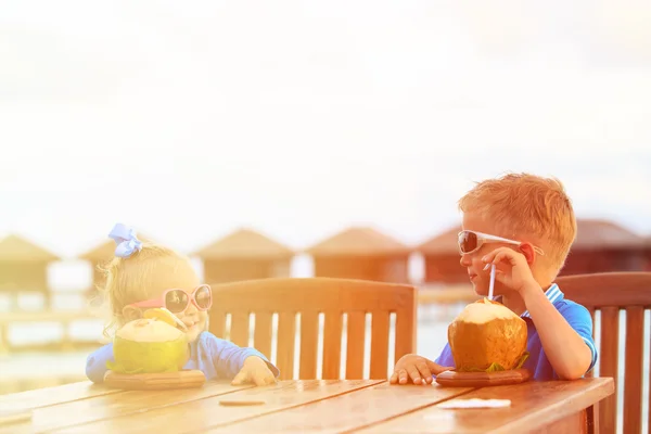 Bambino e ragazza bere cocktail di cocco sulla spiaggia resort — Foto Stock