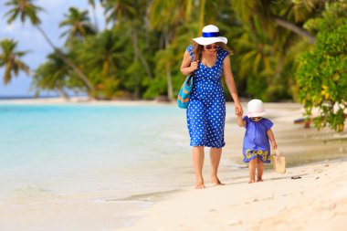 Anne ve sevimli küçük kız Sahilde yürüyüş