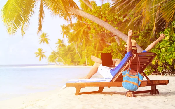 Щасливий молодий чоловік з ноутбуком на пляжі — стокове фото