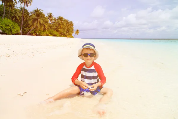 Ładny chłopczyk zrelaksować się na tropikalnej plaży — Zdjęcie stockowe