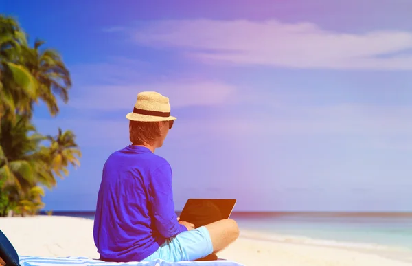 Homme avec ordinateur portable sur la plage tropicale — Photo