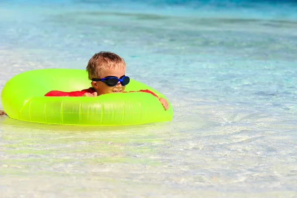 Heureux petit garçon avec anneau de vie s'amuse sur la plage — Photo