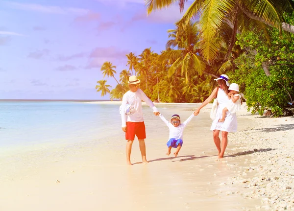 Gezin met twee kinderen spelen op het strand — Stockfoto