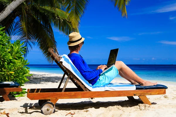 Man med laptop på tropical beach — Stockfoto