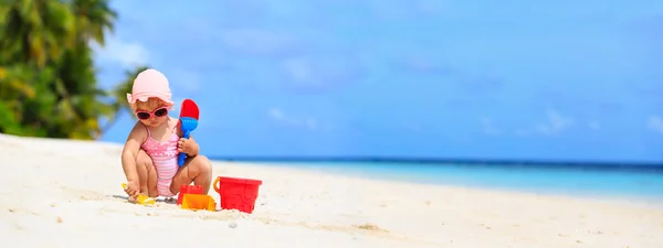 Roztomilá holčička hrát s pískem na pláži — Stock fotografie