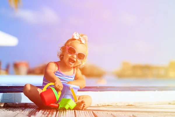 Schattig klein meisje spelen in zwembad op strand — Stockfoto