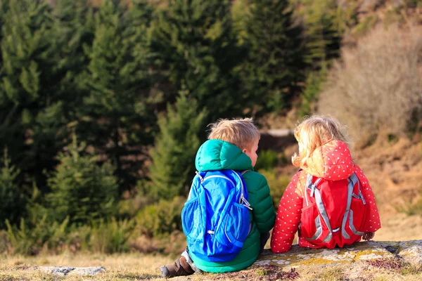 Niño y niña con mochilas descansando en las montañas —  Fotos de Stock