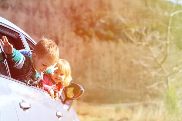 Happy little boy and girl travel by car in nature — Stock Photo, Image