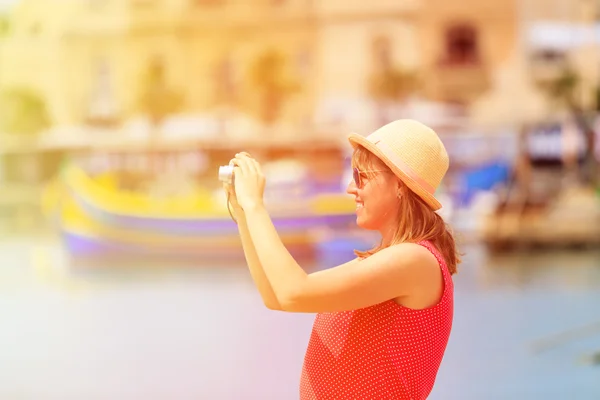 Tourist making photo of colorful traditional boats in Malta — Stock Photo, Image