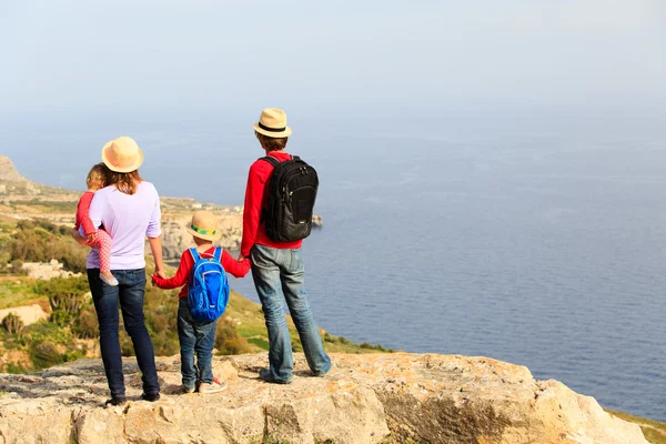 Familia con dos niños haciendo senderismo en montañas escénicas — Foto de Stock