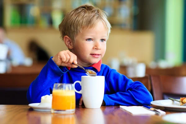 Mignon petit garçon manger le petit déjeuner dans café — Photo