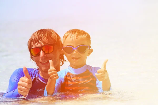 Happy father and son swimming on beach — Stock Photo, Image