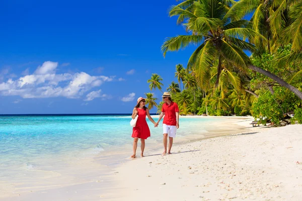 Happy loving couple walking on summer beach — Stock Photo, Image