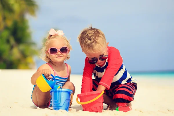 Sevimli küçük çocuk ve yürümeye başlayan çocuk kız oyun kum plajı ile — Stok fotoğraf