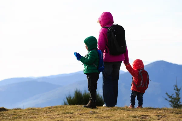 Mor med två barn vandring i bergen — Stockfoto