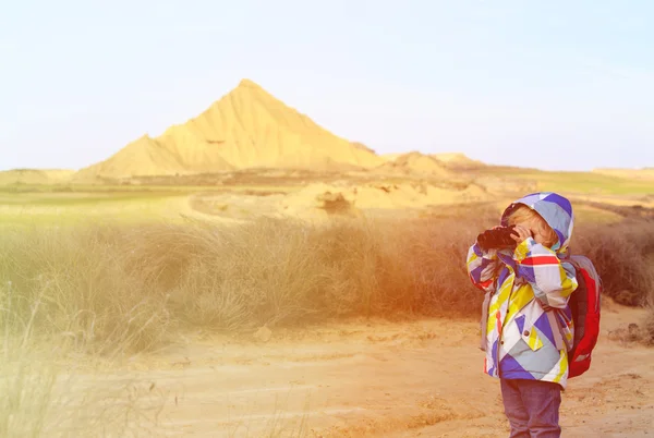 Niña mirando a través de prismáticos en las montañas — Foto de Stock