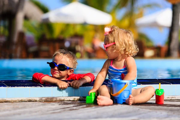 Malý chlapec a dívka hraje v bazénu — Stock fotografie