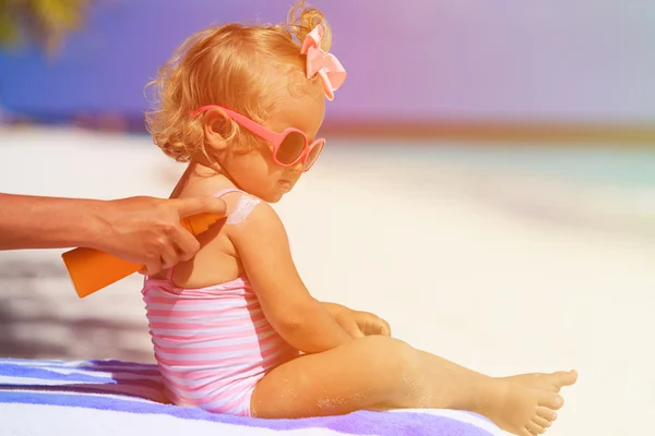 Moeder sunblock room toe te passen op dochter schouder — Stockfoto