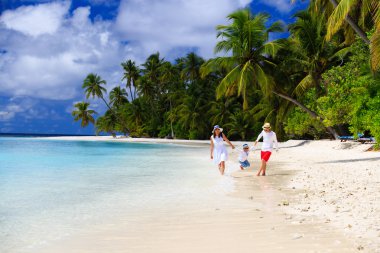 Kumsalda oynayan çocuk ile aile