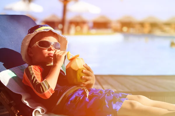 Menino bebendo coquetel de coco na praia tropical — Fotografia de Stock