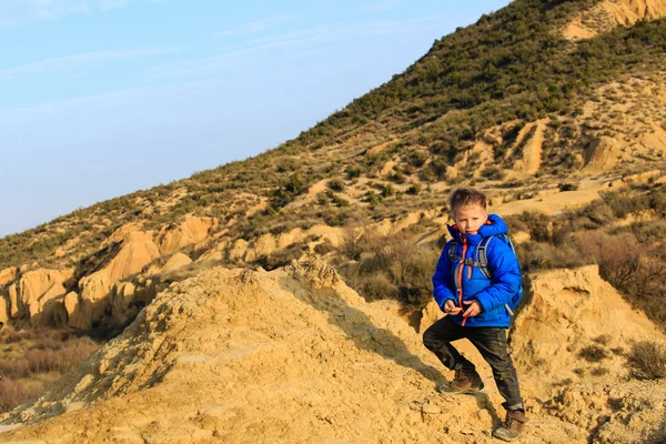 Malý chlapec s cestovní batoh v horách — Stock fotografie