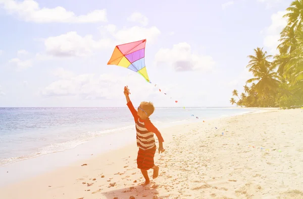 Μικρό αγόρι που φέρουν ένα χαρταετό σε τροπική παραλία — Φωτογραφία Αρχείου