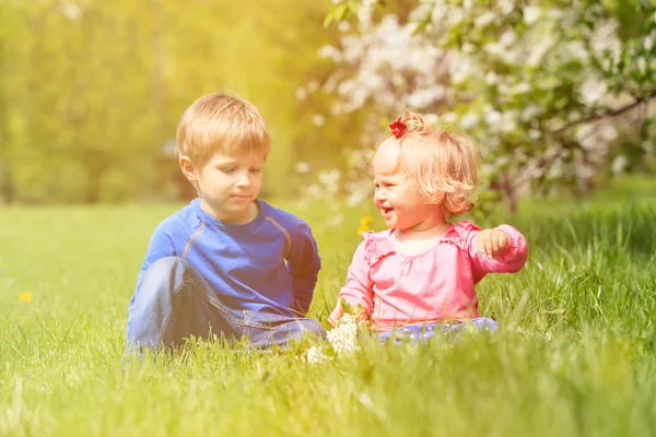 Niños felices juegan con flores de primavera — Foto de Stock