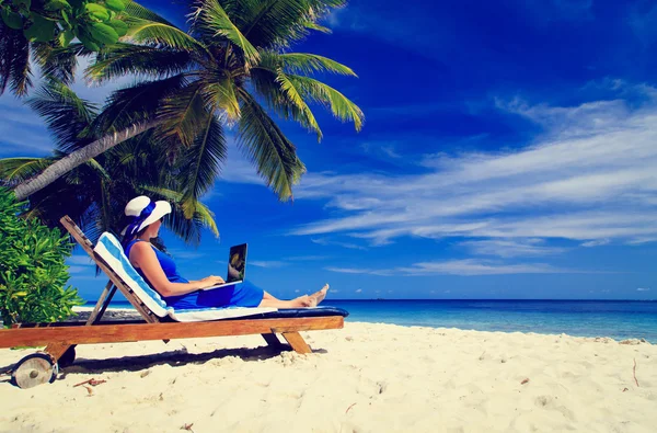 Junge Frau mit Laptop am tropischen Strand — Stockfoto