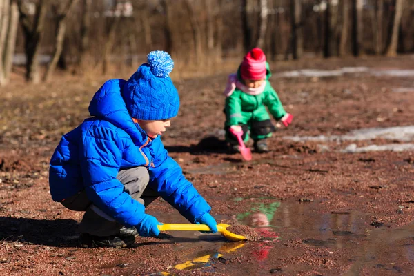 Little boy and girl playing with water in spring — Stock Photo, Image