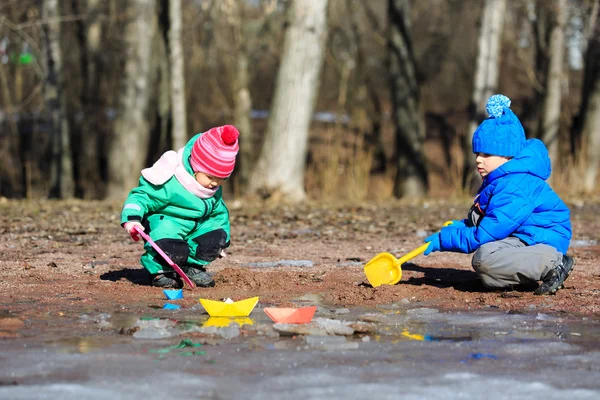 Little boy and girl playing with water in spring — Stock Photo, Image
