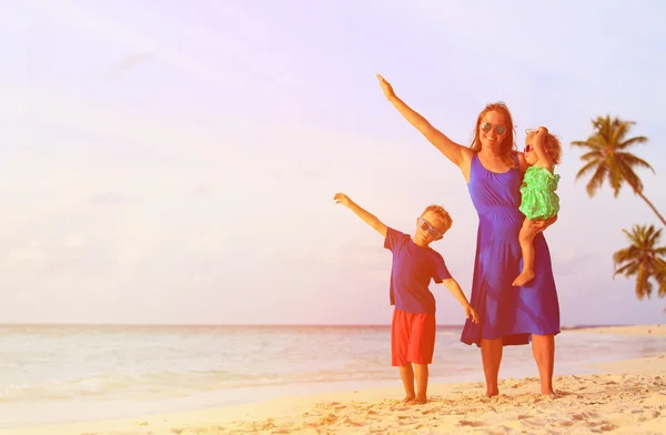 Mother and two kids flying on the beach — Stock Photo, Image