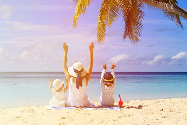 Madre con due bambini mani in alto sulla spiaggia — Foto Stock