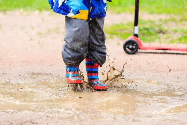 Niño jugando en charco de agua, niños al aire libre — Foto de Stock