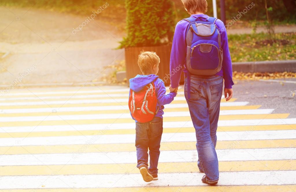 father walking little son to school or daycare