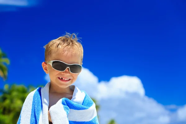 Счастливый маленький мальчик смеется завернутый в пляжное полотенце — стоковое фото