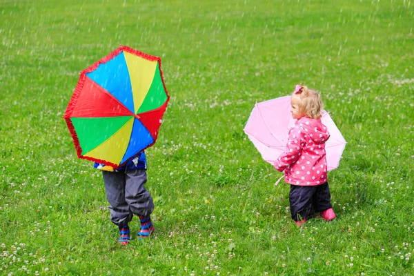 Діти з парасольками на відкритому повітрі в дощовий день — стокове фото