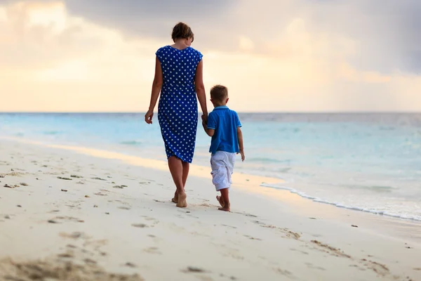 Mère et fils marchant sur la plage du coucher du soleil — Photo