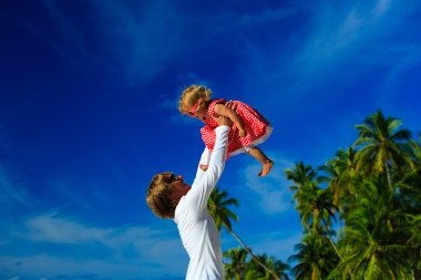 Baba ve küçük kızı gökyüzü tropikal Plajı'nda oynamak
