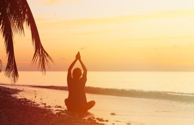 Gün batımında meditasyon genç adam silüeti