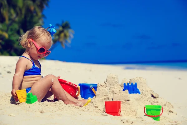 Bonito menina construção sandcastle na praia tropical — Fotografia de Stock