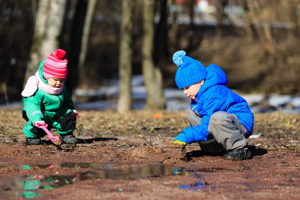 Маленький мальчик и девочка играют весной — стоковое фото