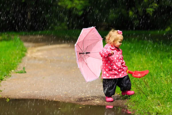 Sevimli küçük kız şemsiye yağmurluk ve botlar ile — Stok fotoğraf