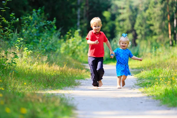 Niño y niña corriendo en el bosque de verano — Foto de Stock