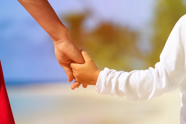 Mère et fils tenant la main sur la plage — Photo