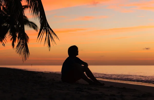 Silueta de hombre joven mirando la puesta del sol — Foto de Stock