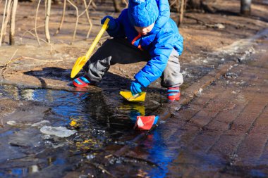 kağıt tekne ile baharda oynayan çocuk